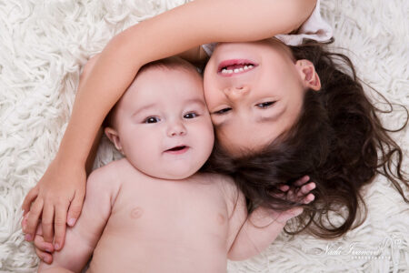 Photographe Clermont Herault Bebe Avec Soeur Sur Une Fourure Blanche