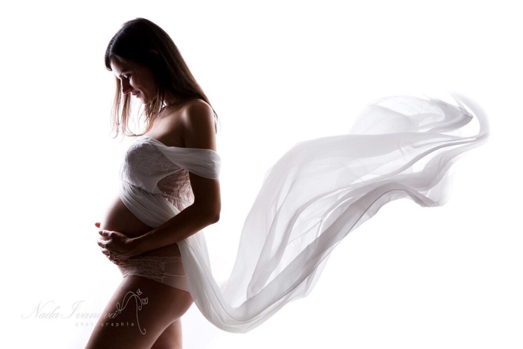 Photoshoot Grossesse D'Une Femme Enceinte Dans Une Robe Longue Blanche